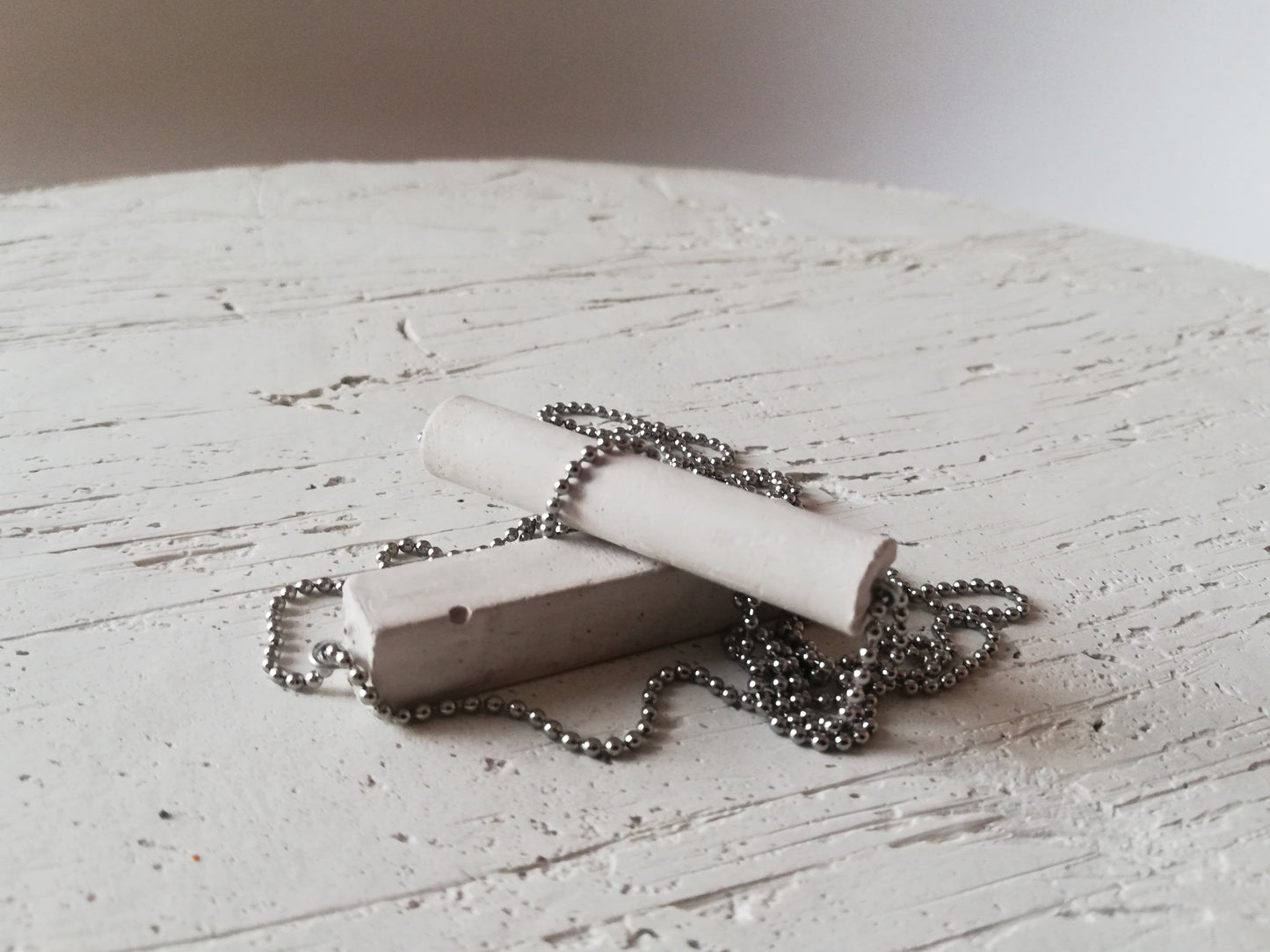 Concrete tube/rectangle on a ball chain //gypsum plaster//